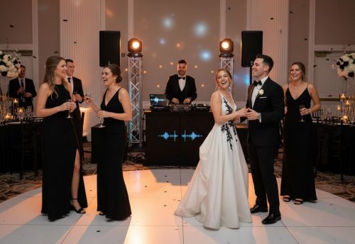 Hochzeits-DJ Auswahl Anleitung: Den perfekten DJ finden 6 Hochzeitsfeier mit tanzenden Gästen in eleganter Kleidung und einem DJ im Hintergrund.