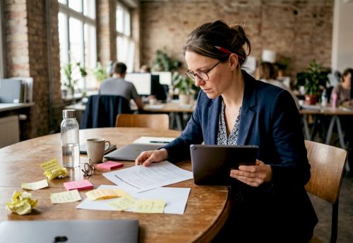 Messe-Event-Checkliste: Unvergessliche Auftritte planen 3 Eine Eventmanagerin prüft ihre To-Do-Liste am Schreibtisch.