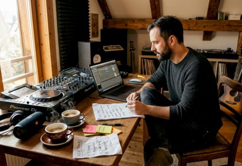 Vorteile maßgeschneiderter Musikkonzepte für Events 5 In einem Studio sitzt ein DJ am Laptop und steuert den Pioneer DJ Controller, um die Musikkonzepte für Events passend zu planen.
