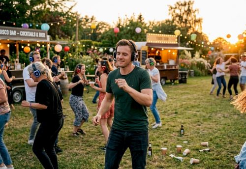 Was ist ein Silent-Disco-Event? Erlebnis erklärt 5 Die Gäste feiern ausgelassen bei einer Silent Disco und bewegen sich rhythmisch zur Musik, die sie über Kopfhörer hören.