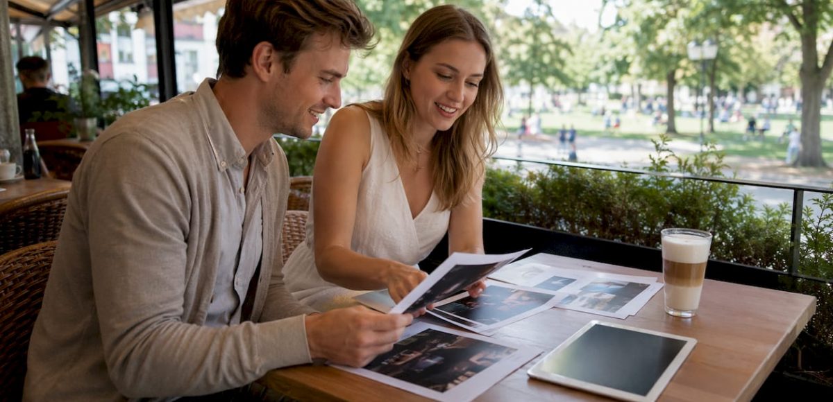 1785086584254 Couple reviewing DJ prices at cafe