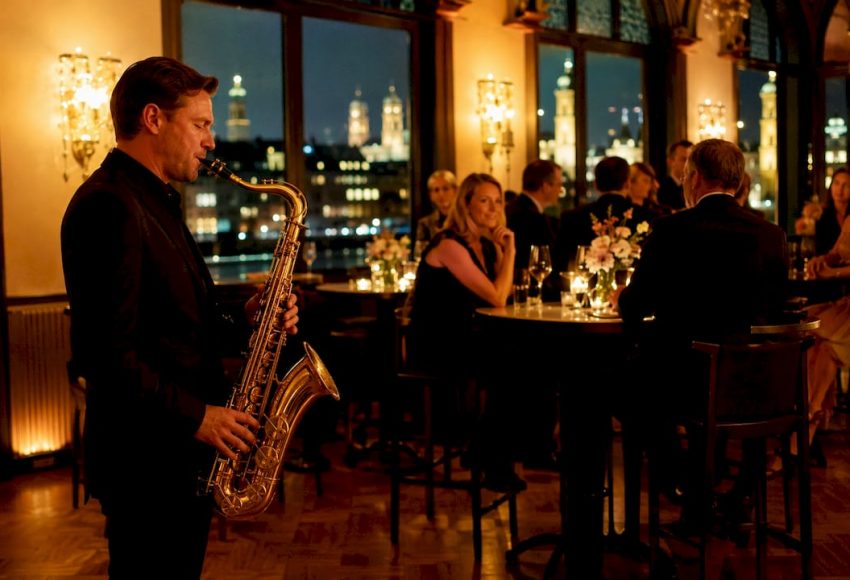 Livemusik einbinden: Vorteile für Events in München 7 Ein Saxophonist spielt bei einer Abendveranstaltung in München, während Gäste an Tischen vor den großen Fenstern sitzen.